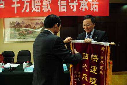 山西千万理赔：新华保险（601336）运营总监陈正阳（右）从杨女士家属手中接过锦旗